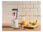 Blender met fruit en yoghurt, sinaasappelsap en bananen op een houten plank.