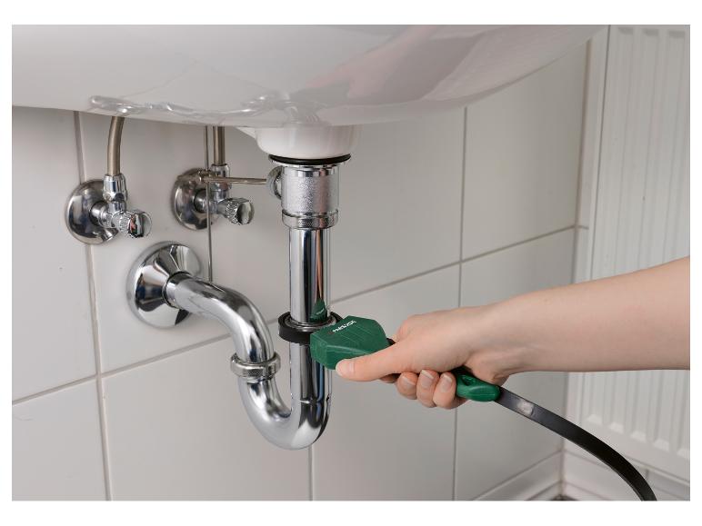 Hand gebruikt een Parkside afvoerreinigingsgereedschap op een gootsteenpijp.