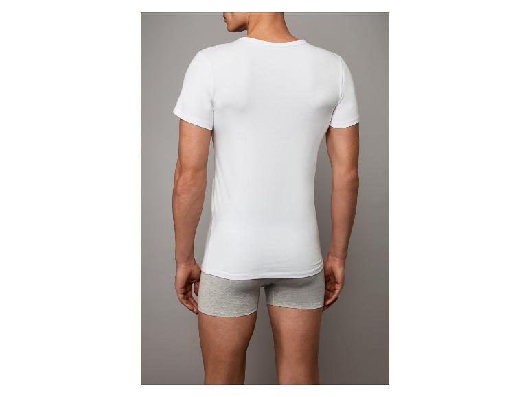 Achteraanzicht van een man in een wit T-shirt en grijze boxershorts.