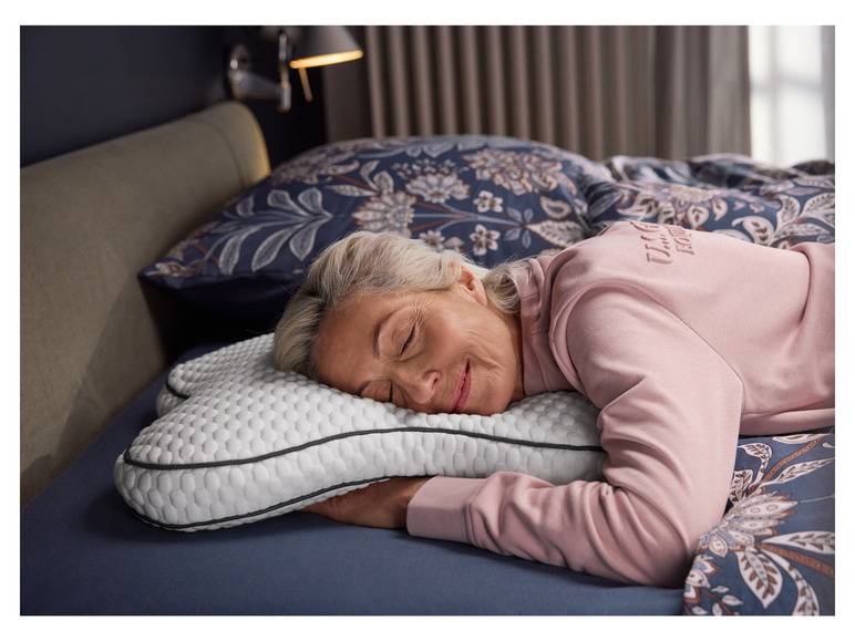 Een vrouw slaapt op een kussen met honingraatpatroon en een blauwe hoes.