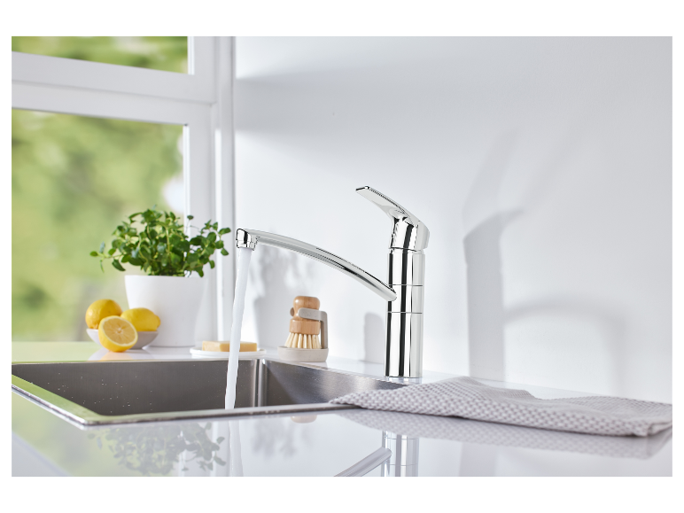 Grohe keukenkraan met stromend water in een roestvrijstalen gootsteen.