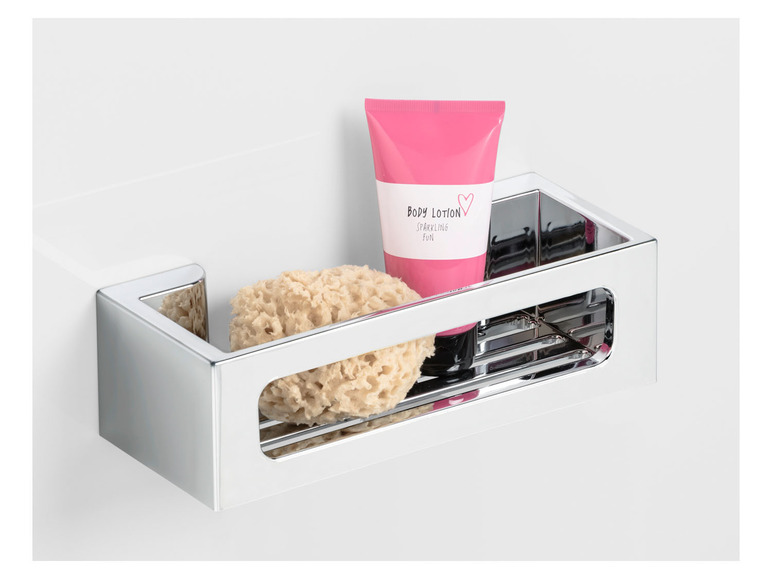 Een chromen badkamerrekje met een spons, bodylotion en een hartje.