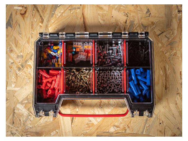 Opbergdoos met diverse bevestigingsmaterialen, waaronder pluggen, schroeven en moeren, op houten achtergrond.