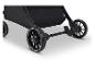 Onderkant van een zwarte kinderwagen met wielen en een rem.
