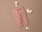 Roze babybroek met houten speelgoed