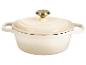 Crèmekleurige gietijzeren braadpan met deksel en goudkleurige knop