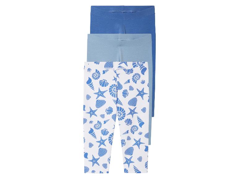 Drie leggings voor kinderen: twee effen blauwe en één met schelpjesprint.