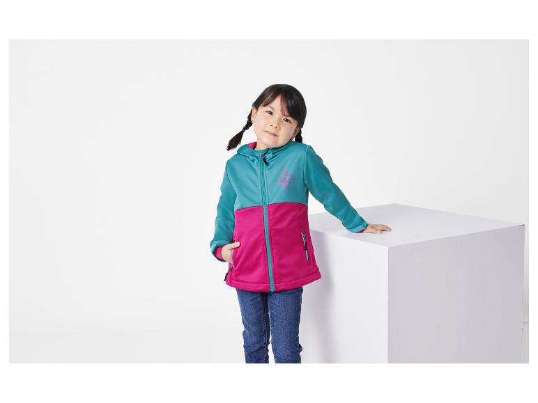Een jong meisje modelleert een turquoise en roze softshell jas van Wilderness Camp.