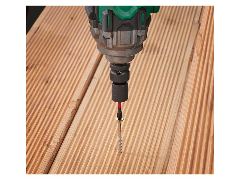 Boormachine die een schroef in een houten plank draait.