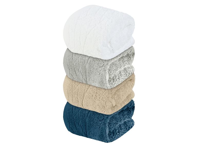 Een stapel badhanddoeken in wit, grijs, beige en blauw.