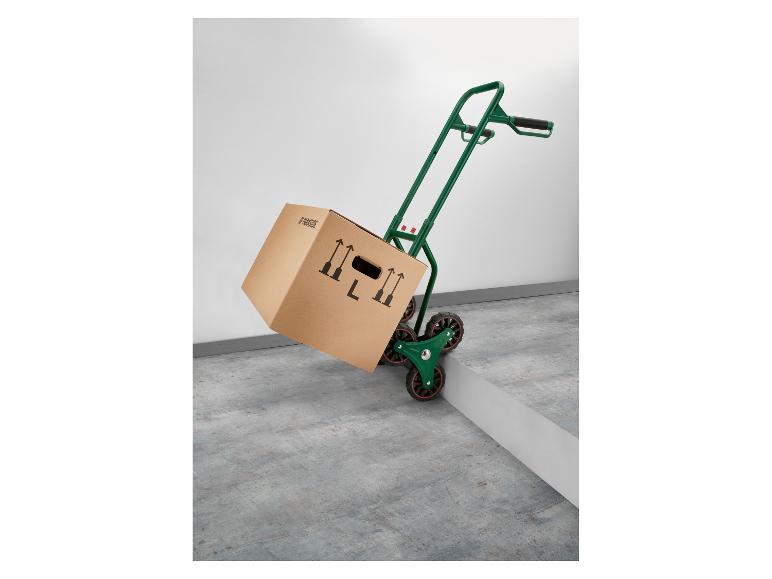 Groene steekwagen met Parkside kartonnen doos die een trede opgaat.