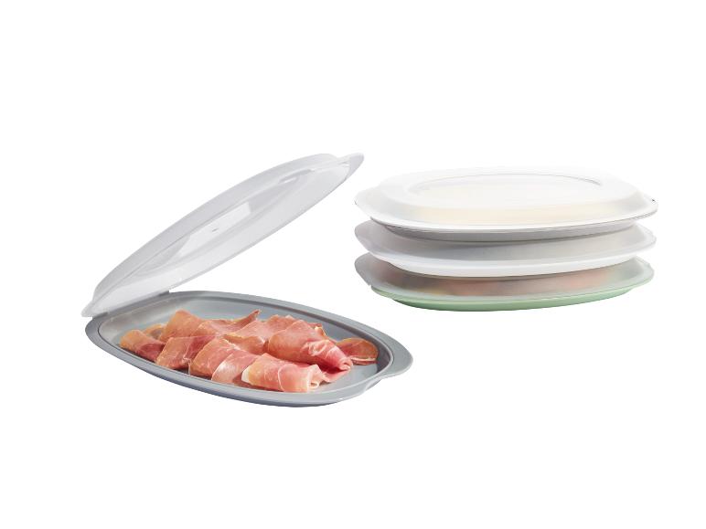 Stapelbare schalen met deksels, één met serranoham.