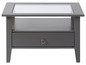 Grijze salontafel met glazen blad en lade.
