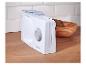 Witte broodsnijmachine met verstelbare dikte, op een houten aanrecht naast een broodmand.