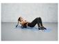 Een vrouw gebruikt een foam roller op een blauwe mat tijdens een workout.