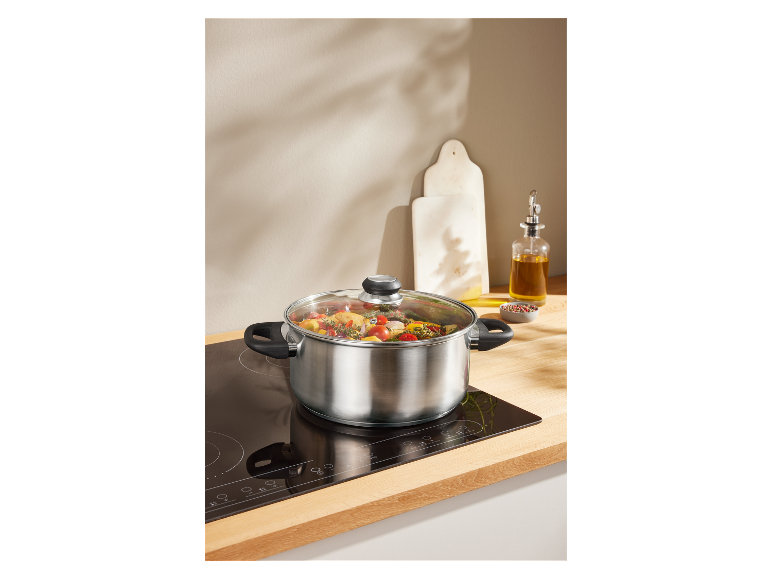 RVS pan met glazen deksel op een inductiekookplaat.