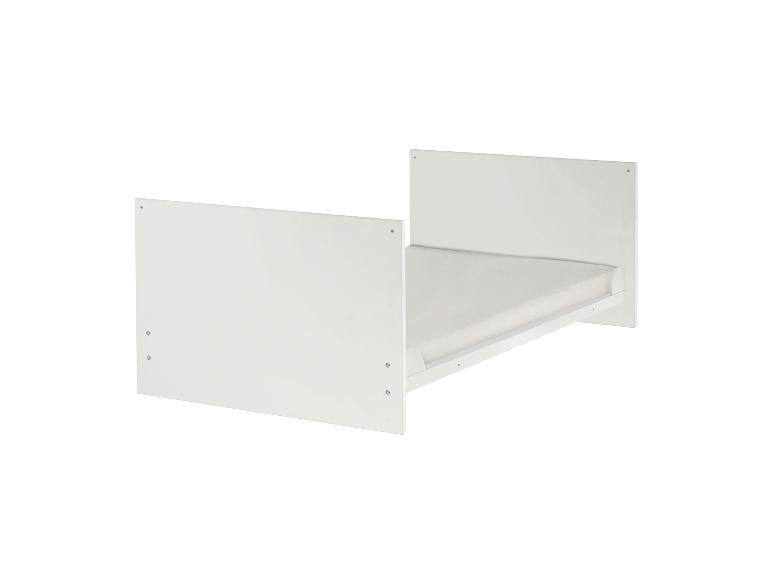 Eenvoudig wit ledikant met matras, ideaal voor een kinderkamer.