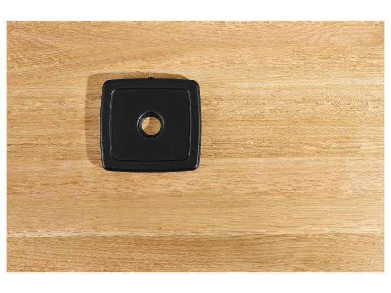 Zwarte vierkante onderzetter op een houten aanrechtblad.