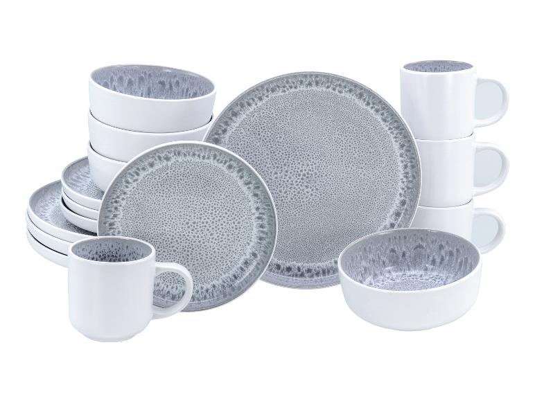Grijs en wit servies met borden, kommen en mokken, met een gespikkeld ontwerp.