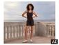 Een vrouw poseert op een terras in de zwarte ESMARA® damesshort. [AI-gegenereerde afbeelding]