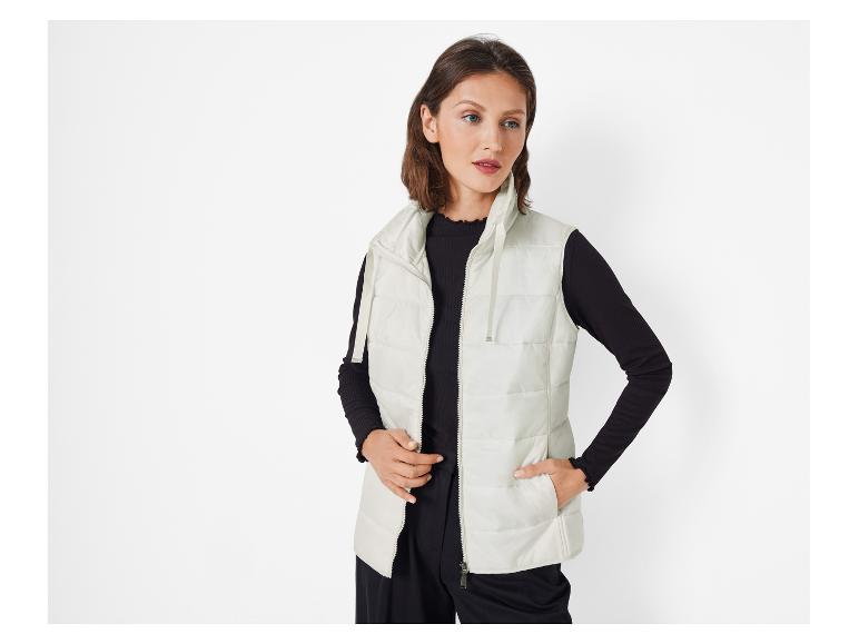 Een vrouw draagt een witte gewatteerde vest