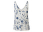 Een wit tanktop met blauwe bloemenprint.
