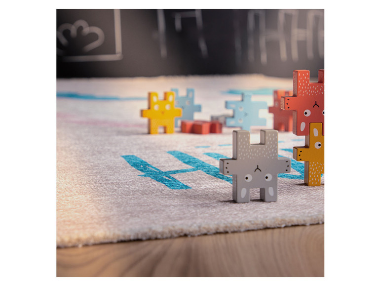 Houten puzzelstukken in de vorm van dieren op een vloerkleed.