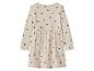 Beige meisjesjurk met zwarte hartjes, lange mouwen en een geplooide rok.