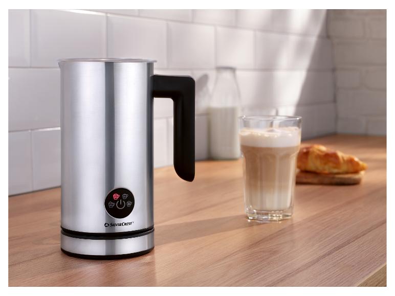 SilverCrest melkopschuimer op een houten aanrecht met een glas latte en een croissant.