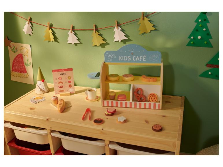 Kinderspeelcafé met houten speelgoedeten, menu en kerstversiering.