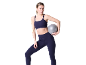 Vrouw in donkerblauwe sportbeha en legging die een kleine fitnessbal vasthoudt.