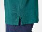 Groen poloshirt en donkerblauwe broek.