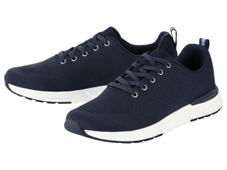 Paar donkerblauwe gebreide sneakers met witte zolen