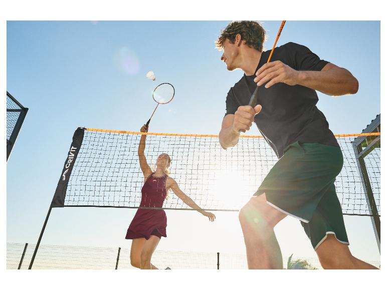 Twee badmintonspelers, een man en een vrouw, op een buitenbaan.