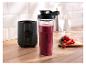 Zwarte SilverCrest blender en fles met paarse smoothie op een houten aanrecht met fruit.