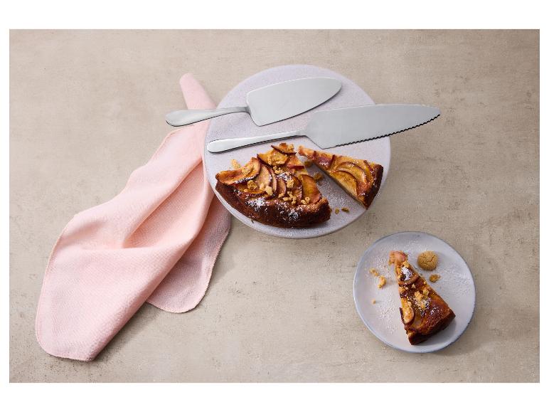 Appeltaart met taartscheppen op een bord en roze servet.