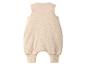 Lichtbeige mouwloze baby romper met boorden aan de pijpen.