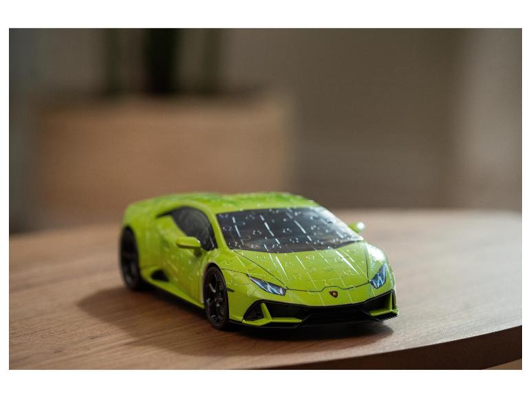 Groene Lamborghini speelgoedauto, met puzzelpatroon, op een houten tafel.