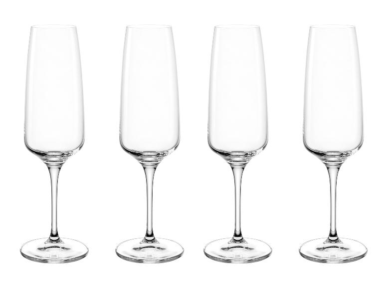 Vier heldere champagneglazen op een witte achtergrond.