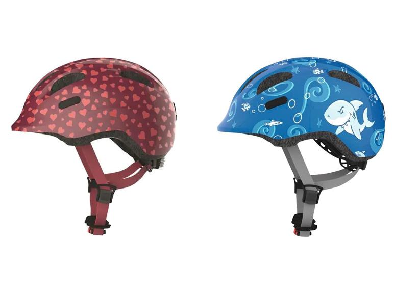Twee kinderhelmen, één met hartjes en één met haaien.