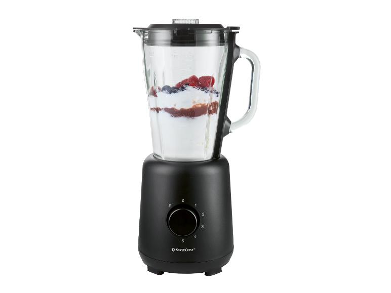 Zwarte blender met glazen kan gevuld met fruit en yoghurt.