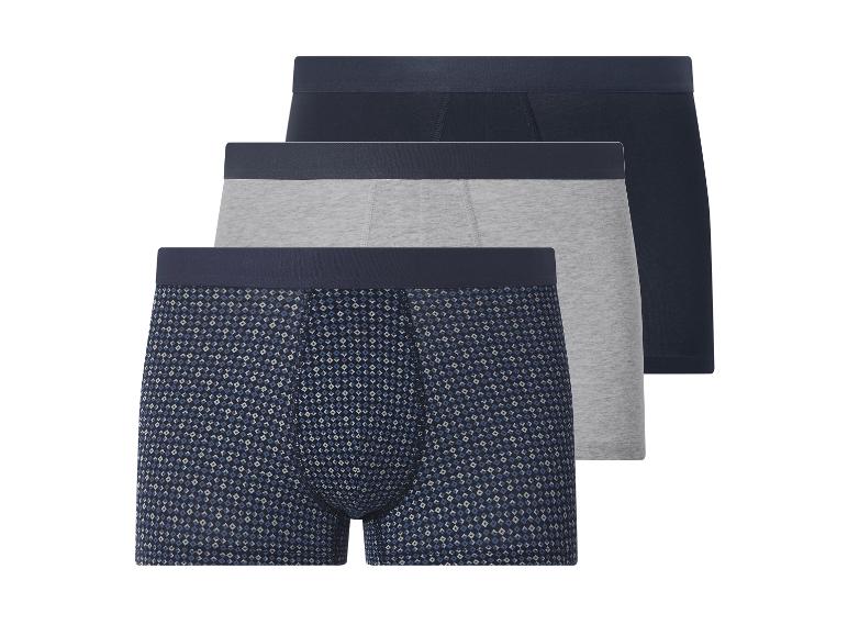 Drie herenboxershorts: één met patroon, één grijs en één donkerblauw.
