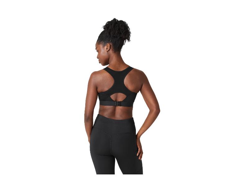 Vrouw van achteren in zwarte sportbeha en legging.