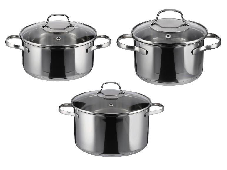Drie roestvrijstalen kookpotten met glazen deksels, op een witte achtergrond