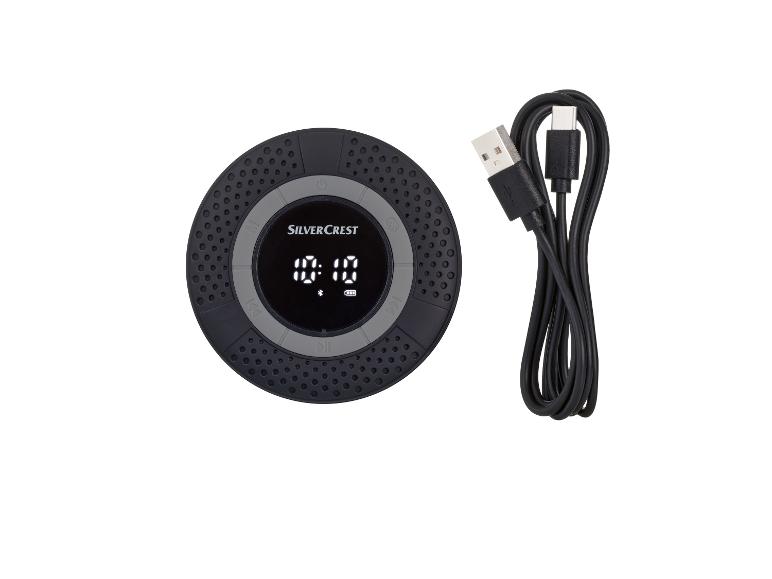 Een ronde, zwarte Bluetooth-speaker van Silvercrest met een USB-kabel.