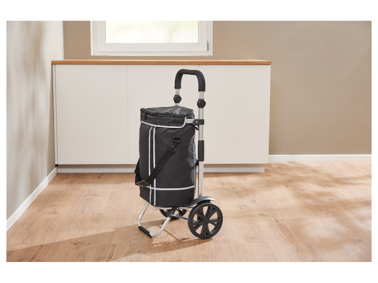 Een zwarte opvouwbare boodschappenkar met koelfunctie staat op een houten vloer.