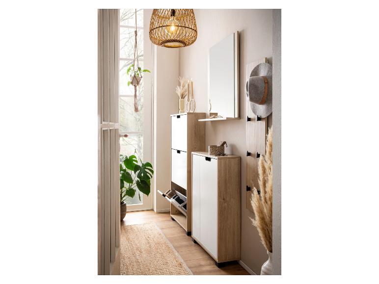 Houten en witte halmeubels met schoenenkast, spiegel, kapstok en rotan hanglamp.