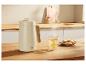 SILVERCREST® thermoskan op een houten tafel naast een kop thee en koekjes.