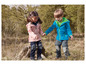 Twee kinderen dragen roze en blauwe softshell jassen in de natuur.
