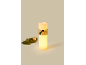 Lichtgevende LED-kaars met jute lint en een klein dennentakje.